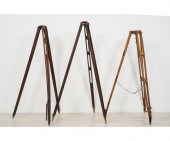 Three wood transit tripods, on