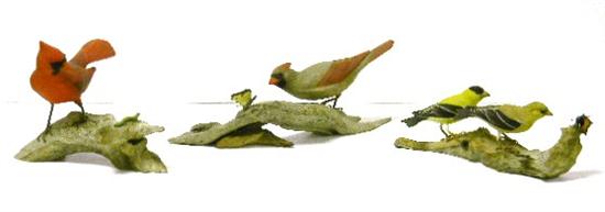 Three wooden bird figurines on