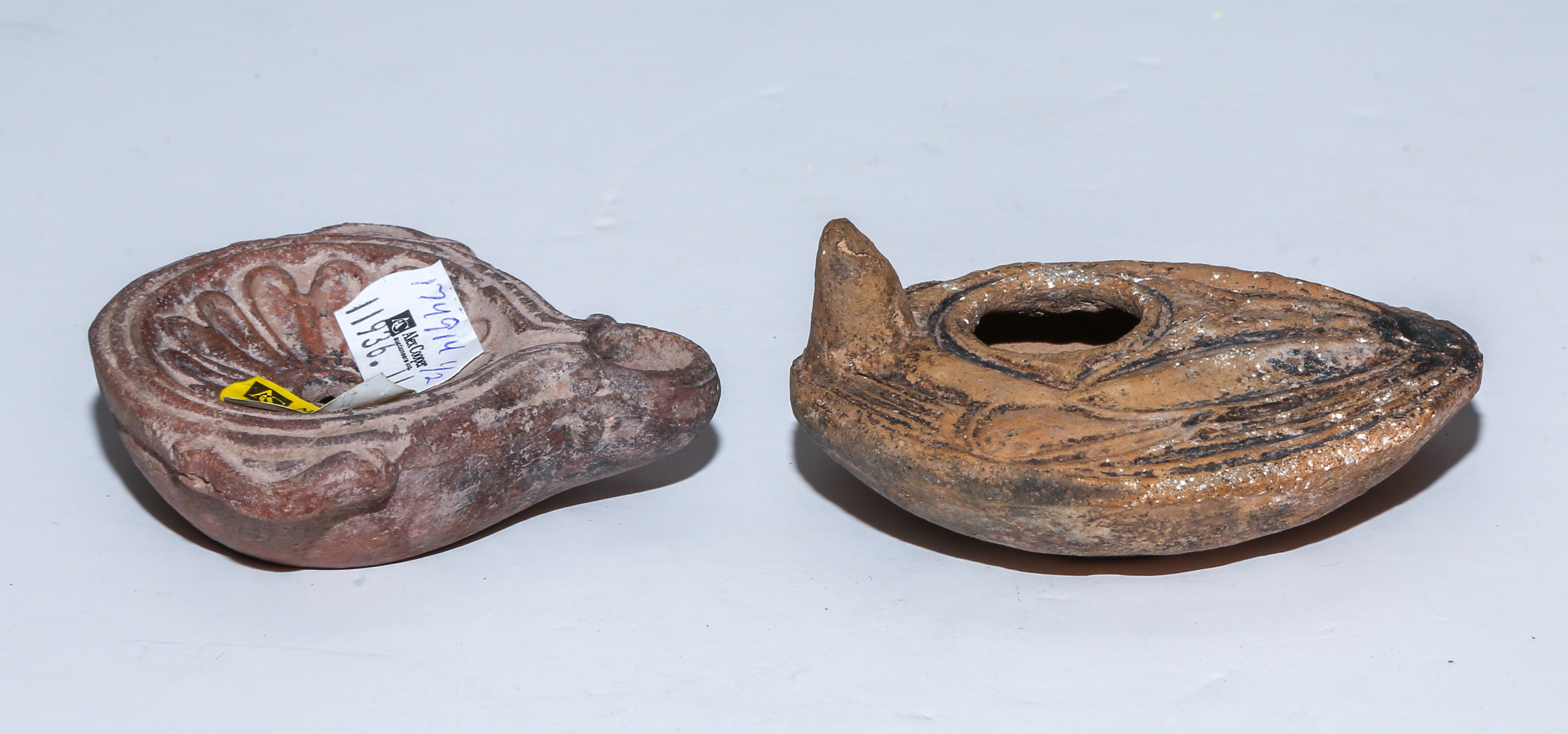 TWO ANCIENT TERRACOTTA OIL LAMPS