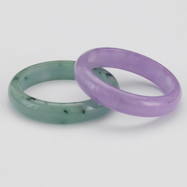 TWO CARVED JADE BANGLE BRACELETS 
