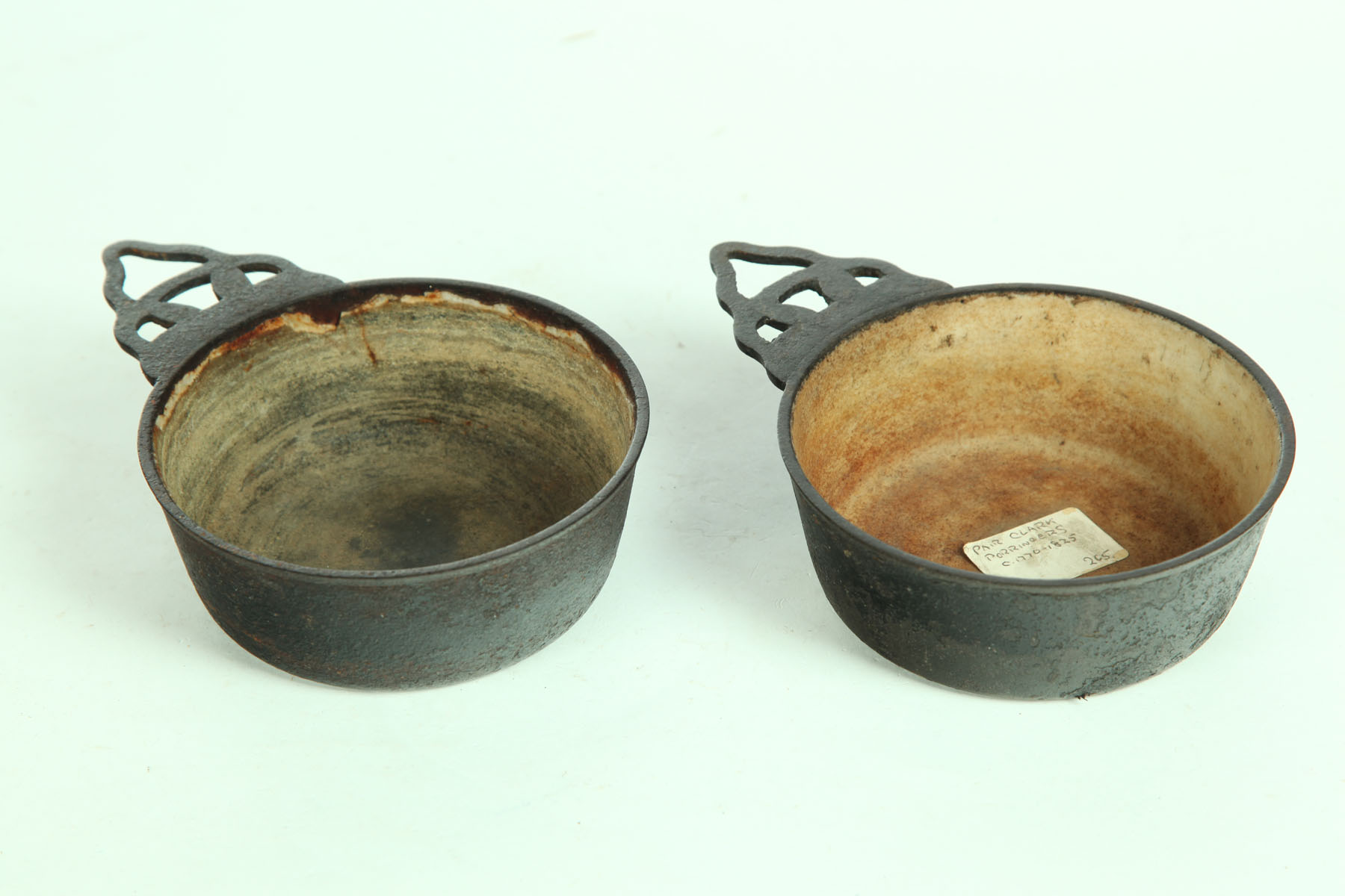 TWO CAST IRON PORRINGERS.  American