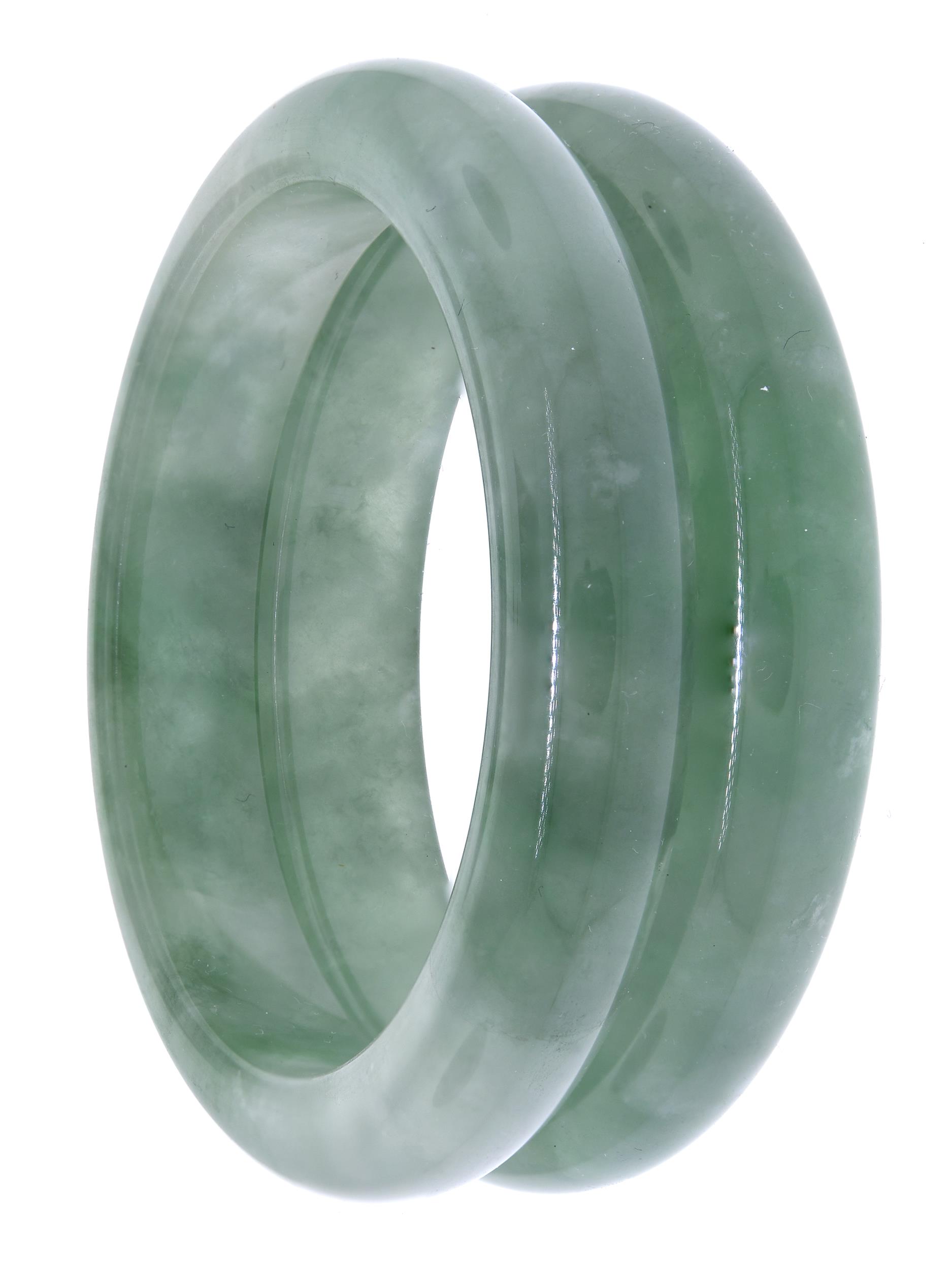 TWO CHINESE GREEN JADE BANGLES. Two