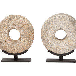 Two Millstone Disks on Metal Stands
