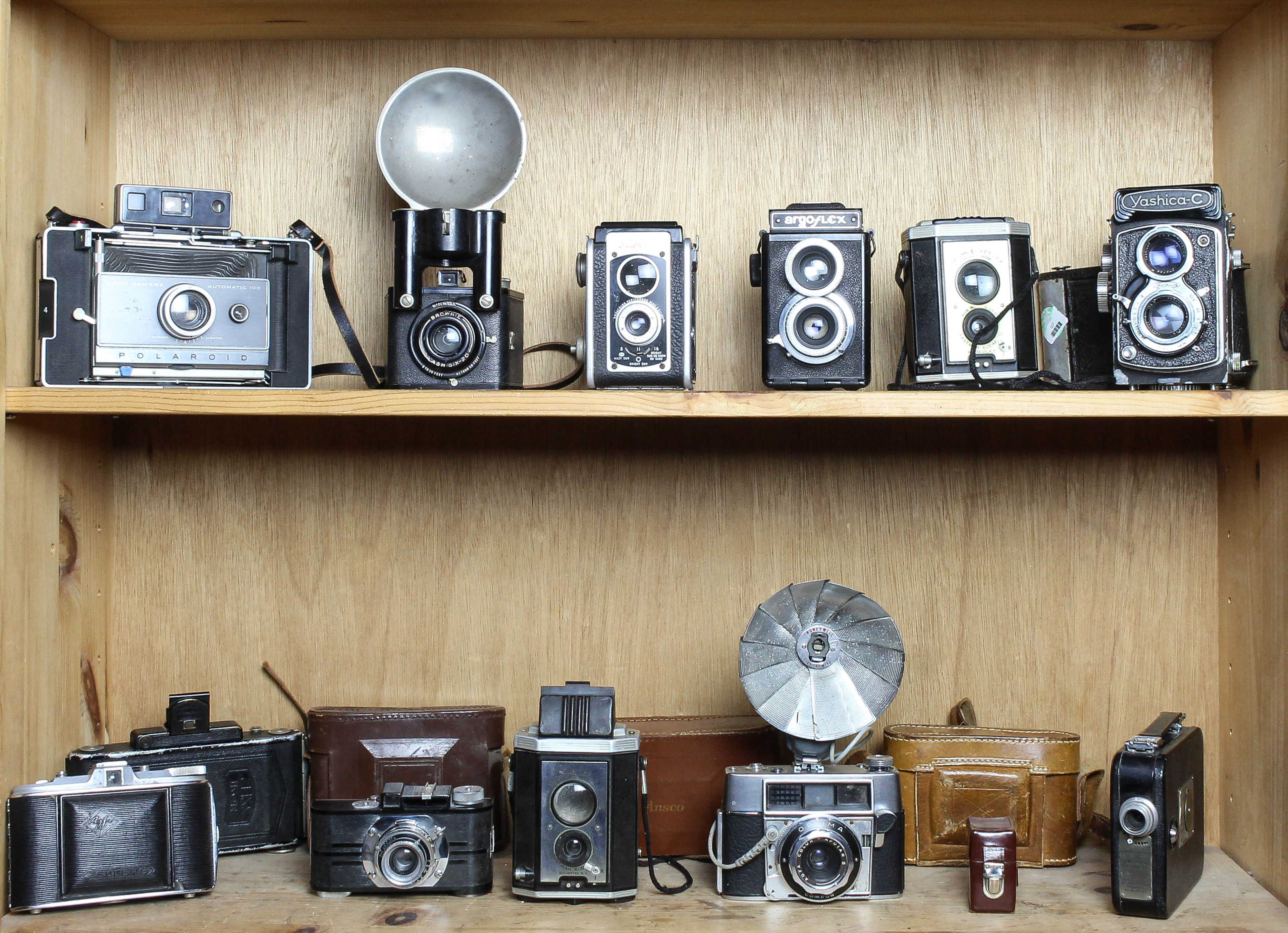 TWO SHELVES OF CAMERAS AND LENSES