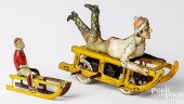 TWO TIN LITHOGRAPH BOY ON SLED