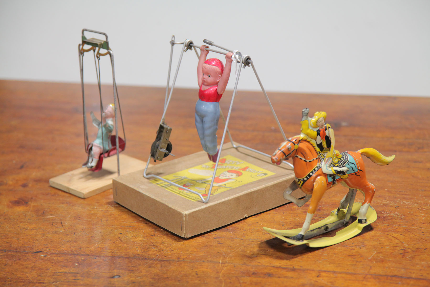 TWO WIND-UP TOYS AND A TIN SWING