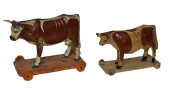 TWO WOODEN COWS ON WHEELED BAS